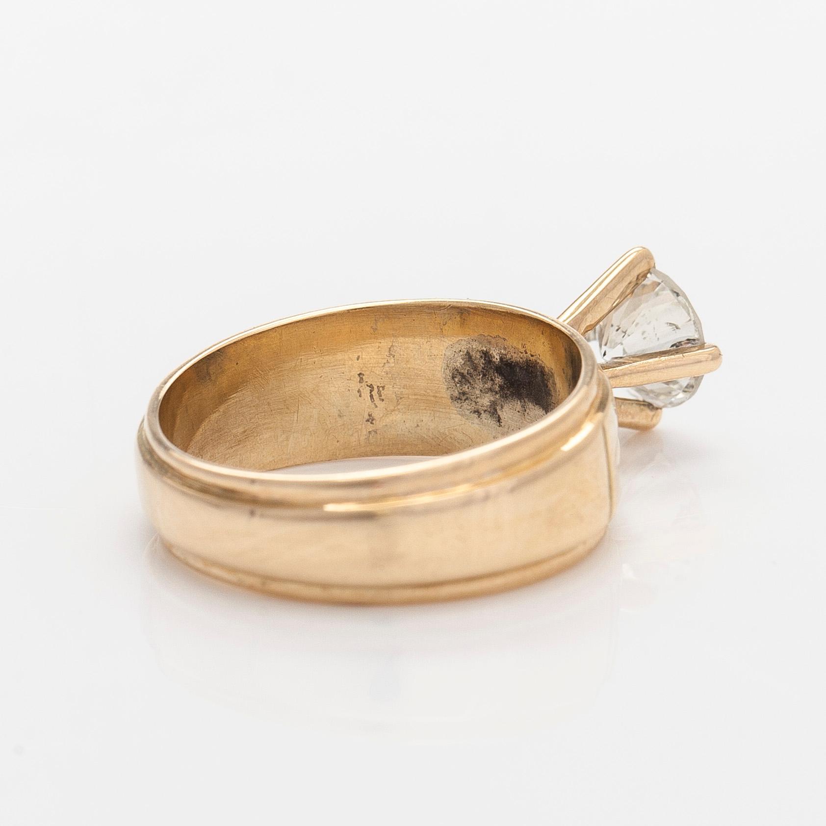 A 14K gold ring, set with a brilliant-cut diamond.