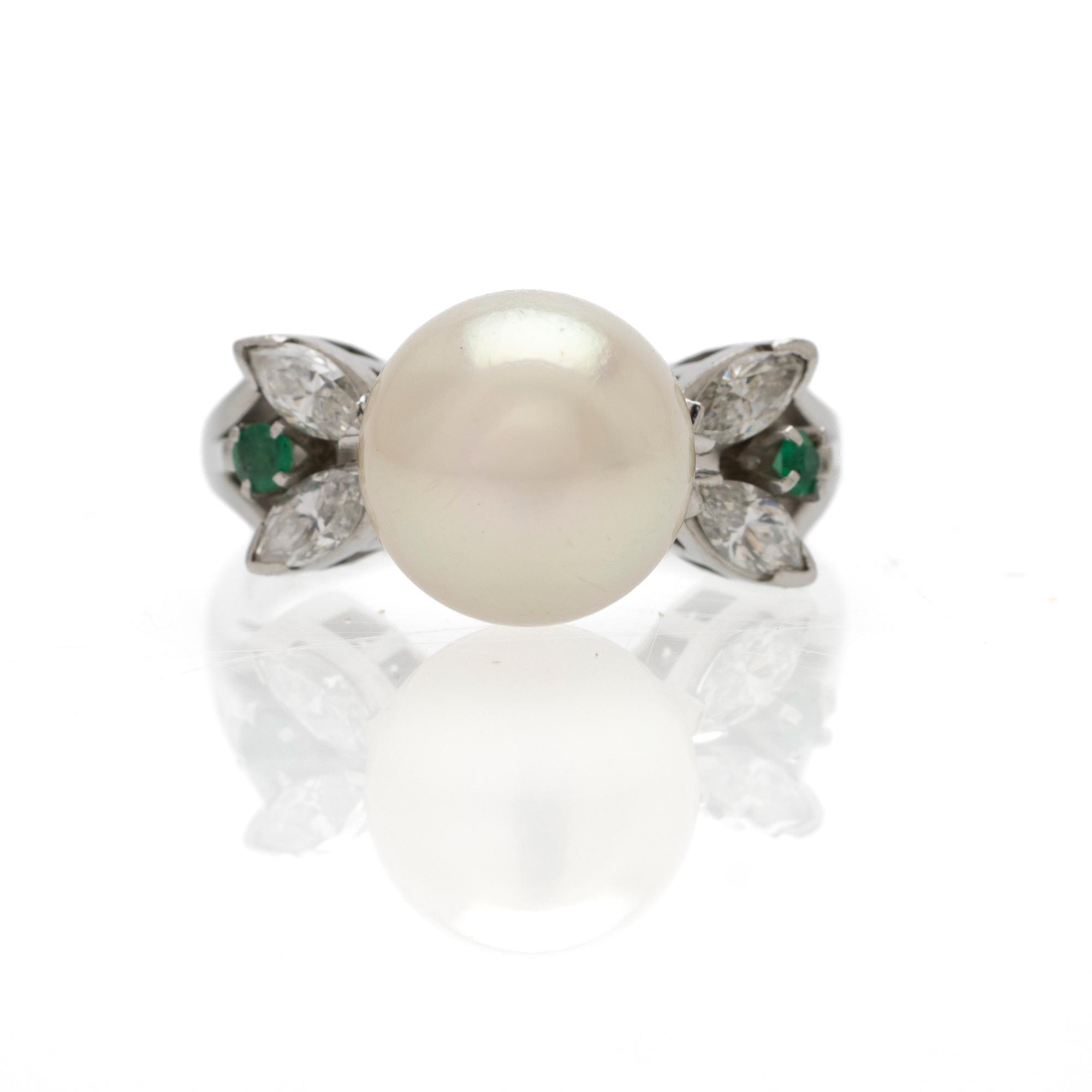 Platinum ring with a cultured pearl, emeralds and diamonds.