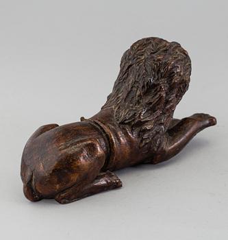 A 17TH CENTURY CARVED WOOD FIGURE OF A LION.