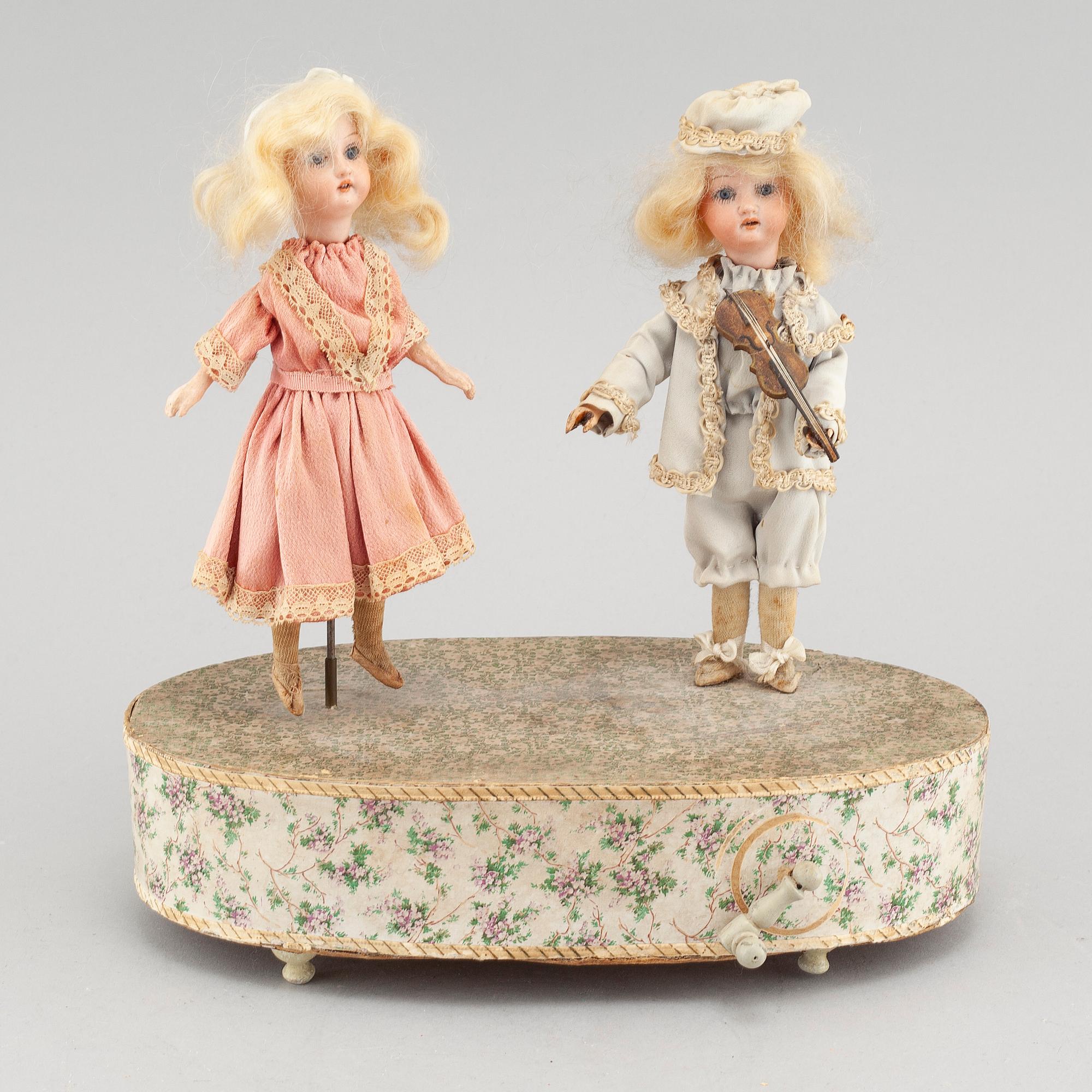 Dolls on a music box, around year 1900.