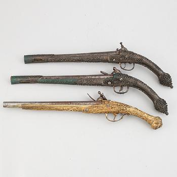 A pair of miquelet pistols and an flintlock pistol, 18/19th Century.