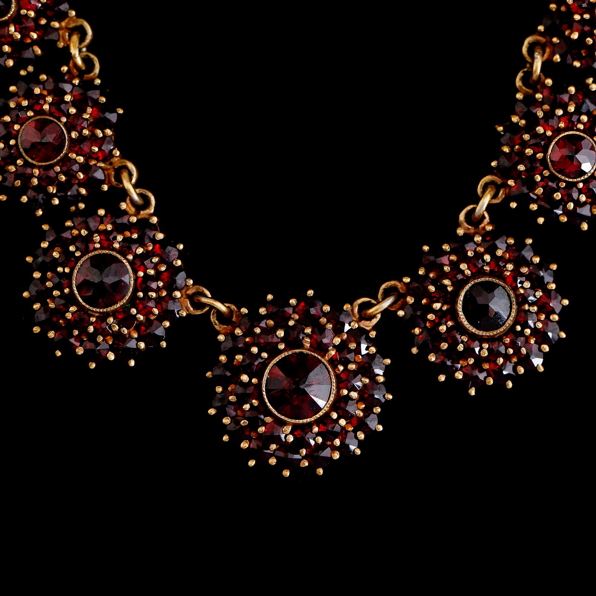 COLLIER OCH ARMBAND, förgylld metall och granater, 1900-talets andra hälft.