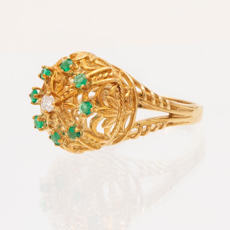 An 18K gold ring set with a round brilliant cut diamond and round single cut emeralds by Franklin Mint 1980.