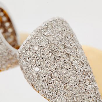 An 18K gold bangle set with round brilliant-cut diamonds.