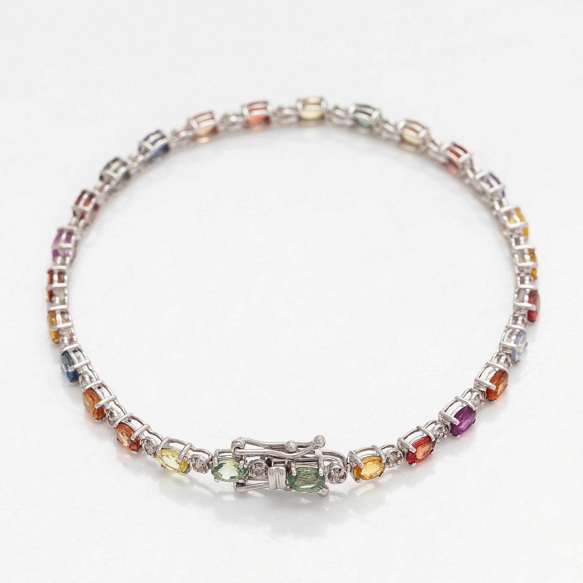 Rannekoru, 18K valkokultaa monivärisillä safiireilla ja timanteilla.