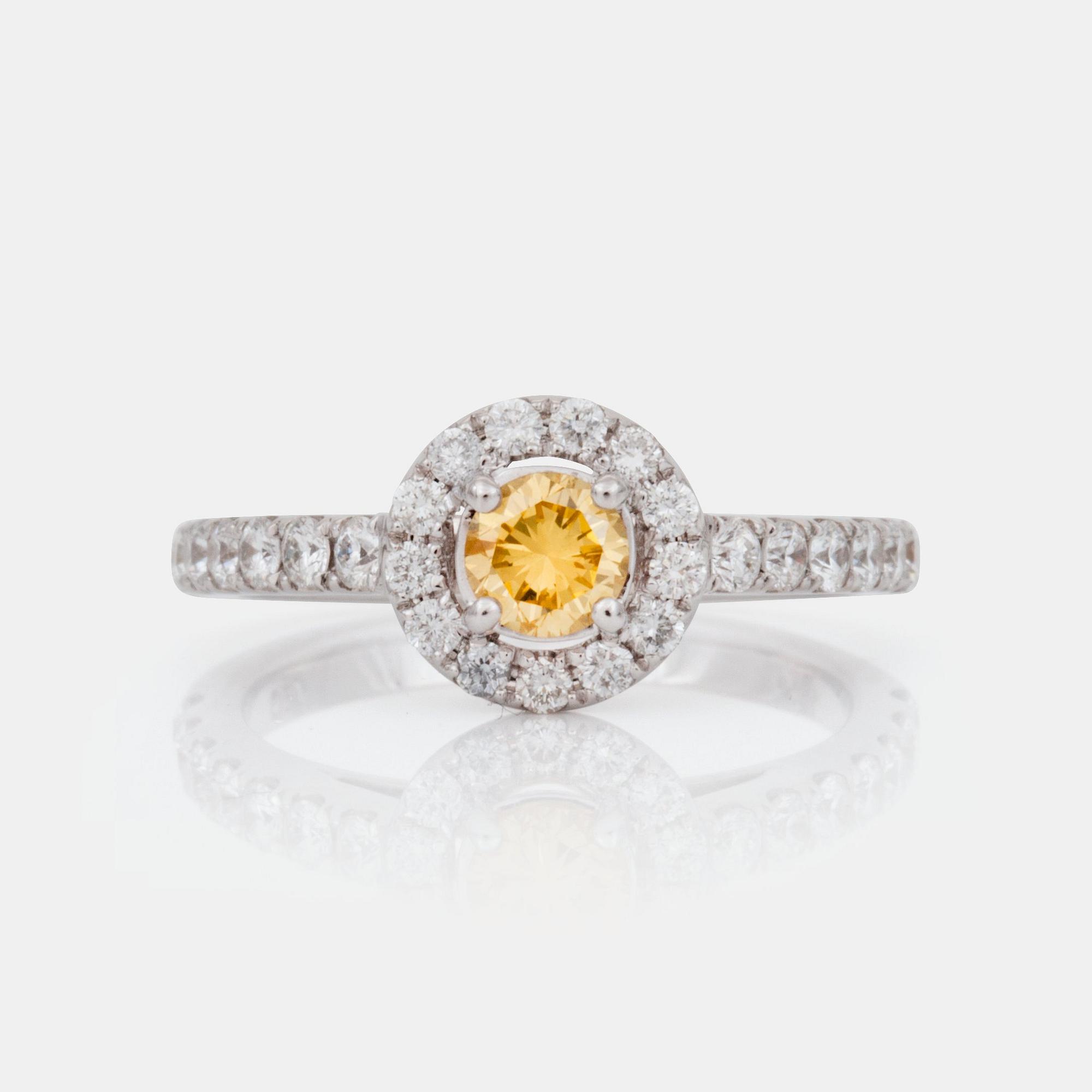 A fancy yellow brilliant-cut diamond, circa 0.36 ct, ring. Pavé-set colourless brilliant-cut diamonds.