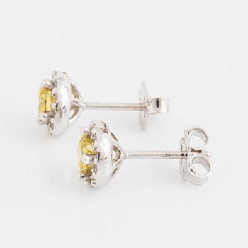 A pair of 18K gold earrings set with color treated yellow diamonds.