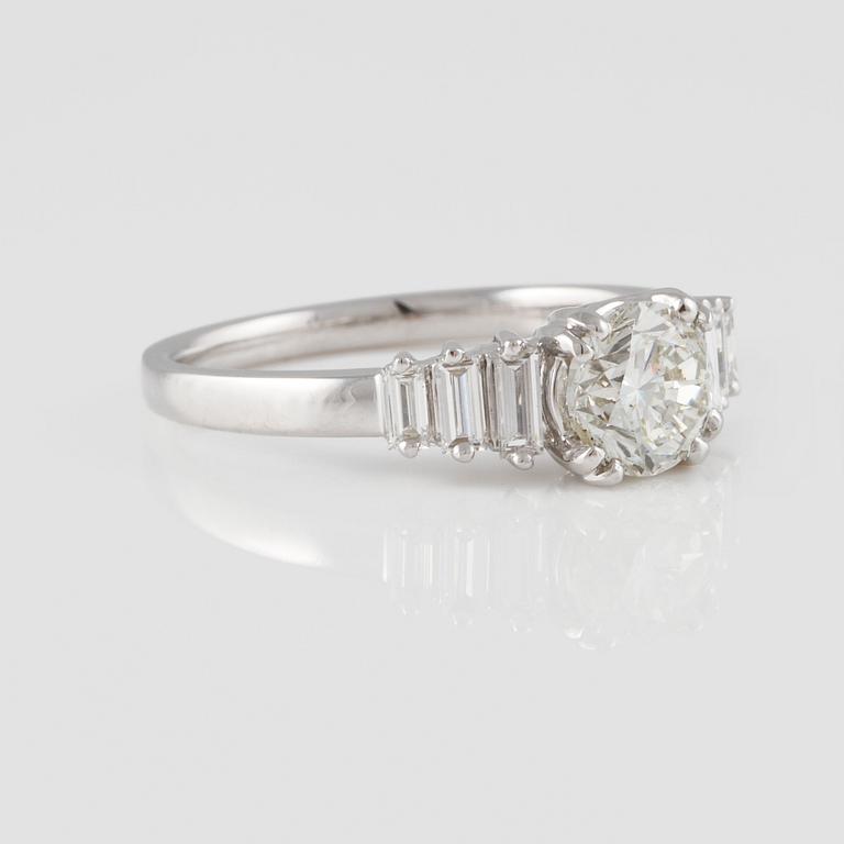 RING, 18K vitguld med briljantslipad diamant ca 1.01 ct samt baguetteslipade diamanter ca 0.29 ct. Vikt 4,0 gram.