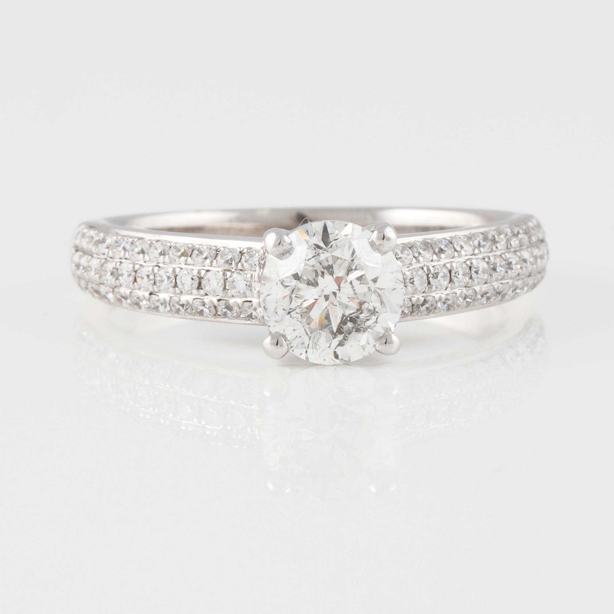 RING, 18K vitguld med briljantslipad diamant ca 1.01 ct samt små diamanter ca 0.37 ct. Vikt 4,3 gram.