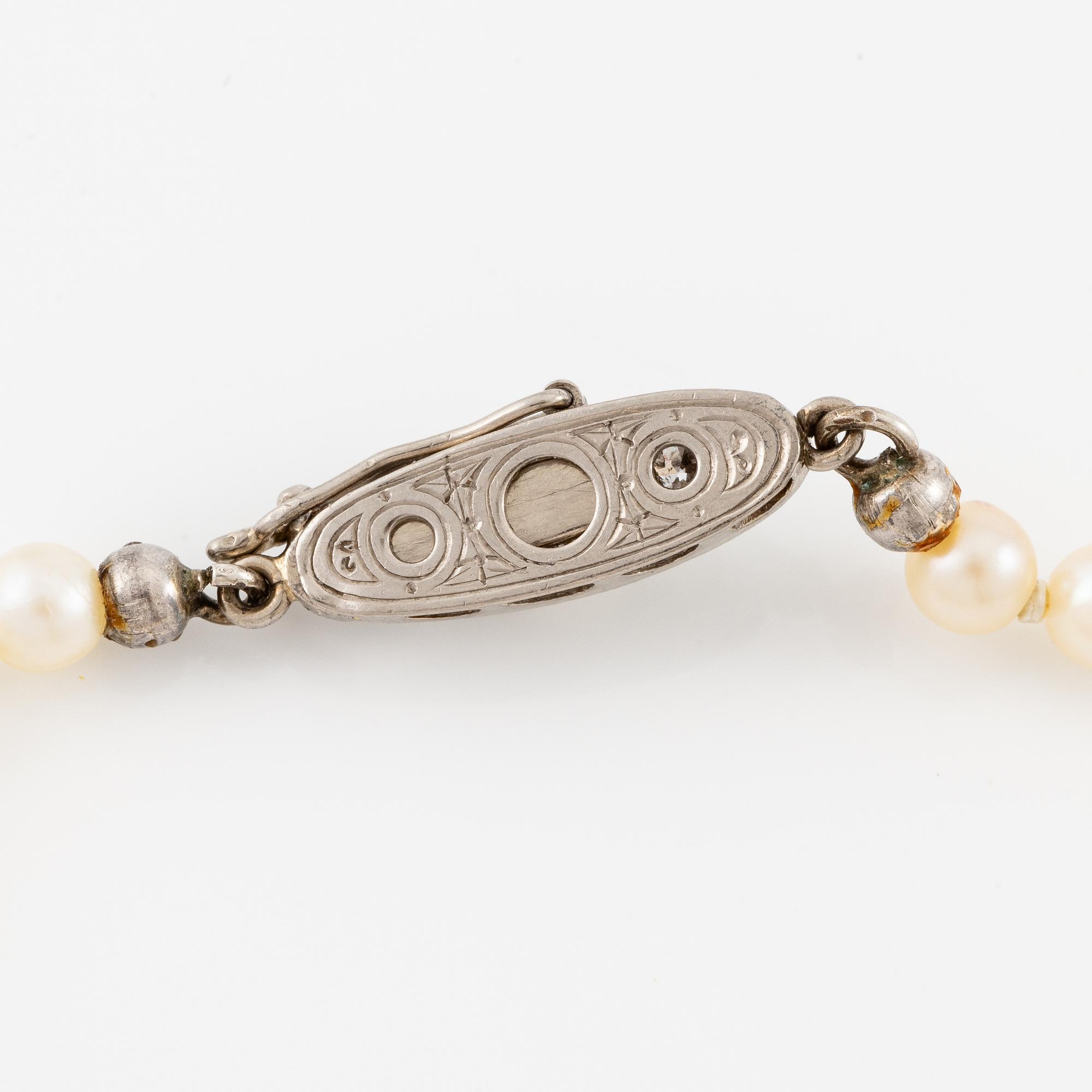 Pearl necklace, with graduated cultured pearls, clasp in gold set with brilliant-cut diamonds and a pearl.