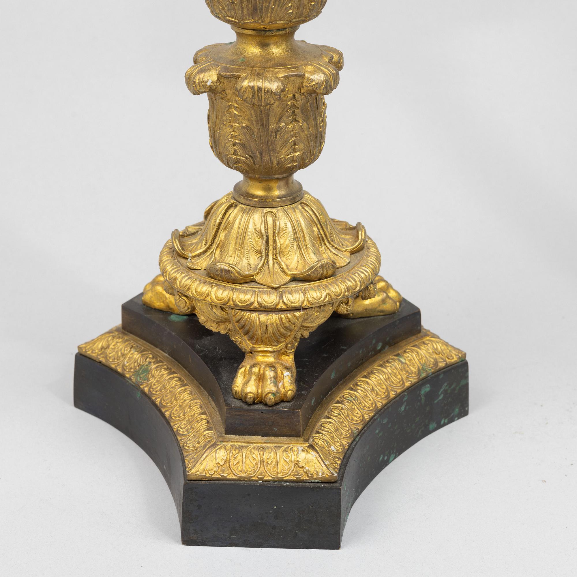 A pair of French Empire-style patinated and gilt bronze five-light candelabra, later part 19th century.