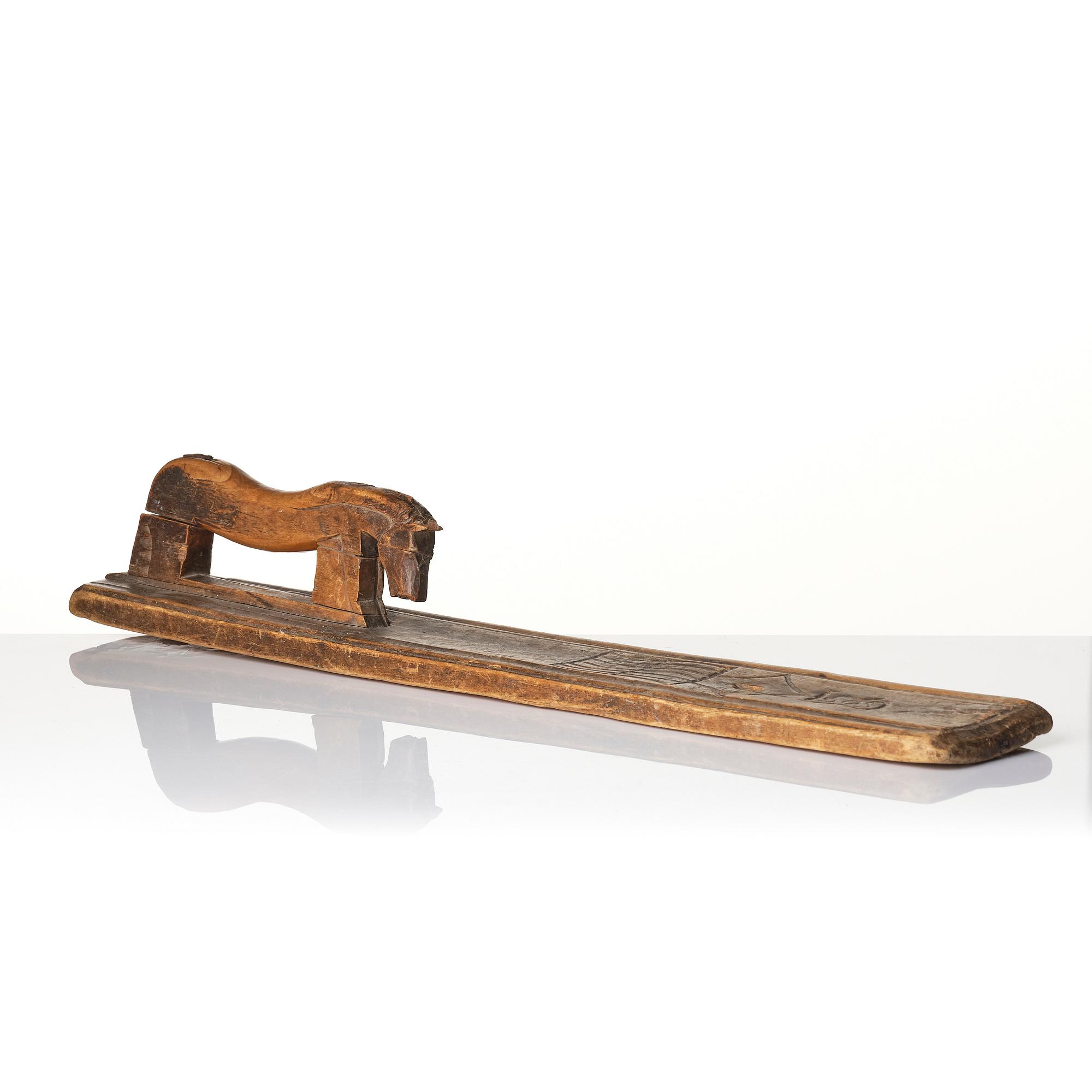 A Swedish folk art carved wringer, dated 1669.
