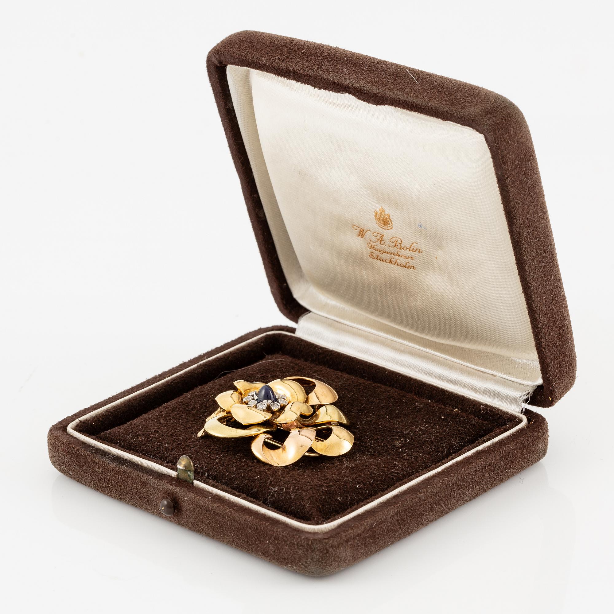 A W.A. Bolin brooch 18K gold with a cabochon-cut sapphire and rose-cut diamonds, Stockholm 1942.