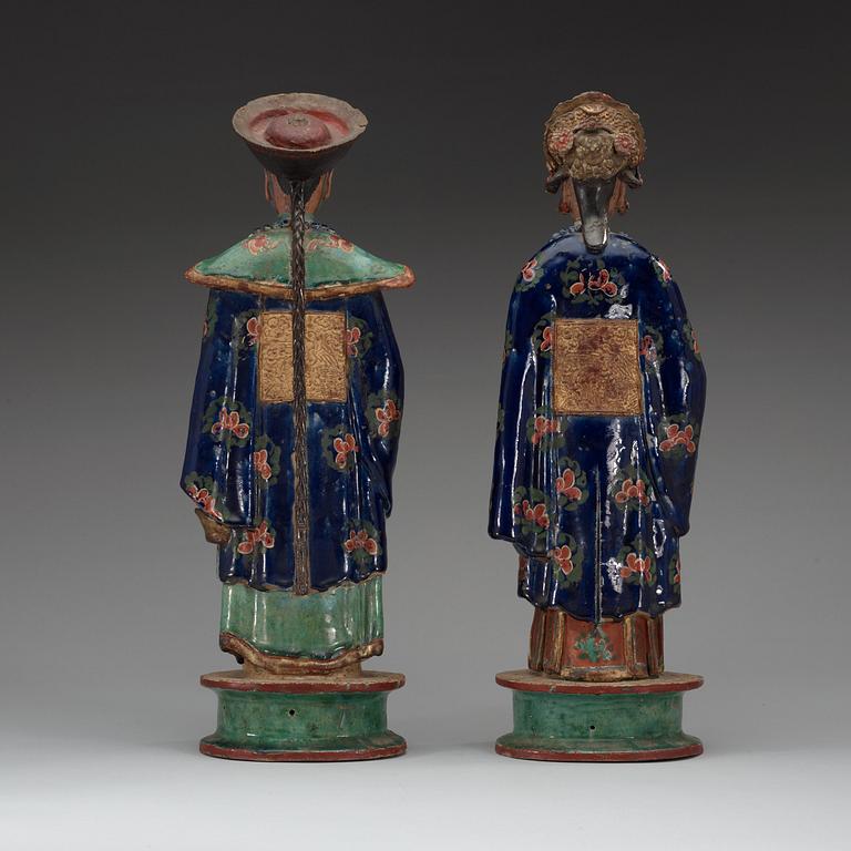 A pair of pottery figures of a Chinese official and his lady, Qing dynasty.