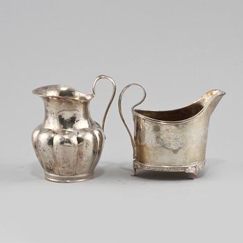 KANNOR, 2 st, silver, Johan Henrik Leffler, Falun 1814 och Claes Peter Hedin, Jönköping 1864. Sammanlagd vikt 180 g.