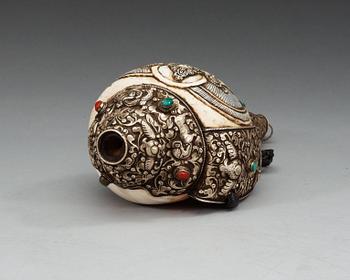 A elaborately decorated ritual Tibetan Conch-shell horn.