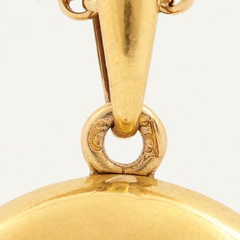 An 18K gold locket set with rose-cut diamonds.