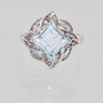 RING, 18K vitguld med carréslipad blå topas 4.07 ct samt baguett och briljantslipade diamanter 0.36 ct. Vikt 4,1 gram.