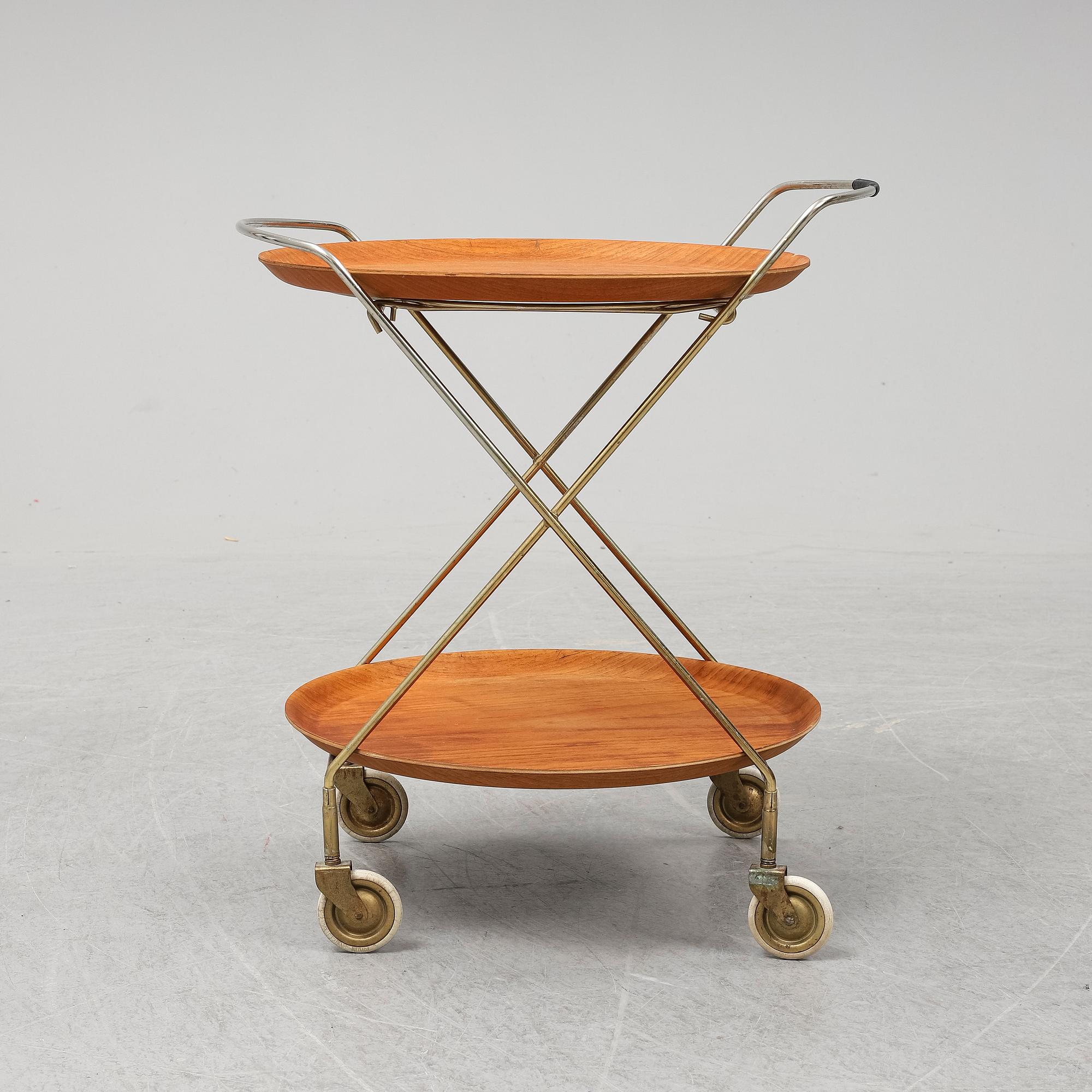 A drinks trolley from J-H Fabrikerna, Sävsjö, 1960-tal.Två lösa, runda brickor fanerade med teak. Märkta J-H Fabrikerna.
