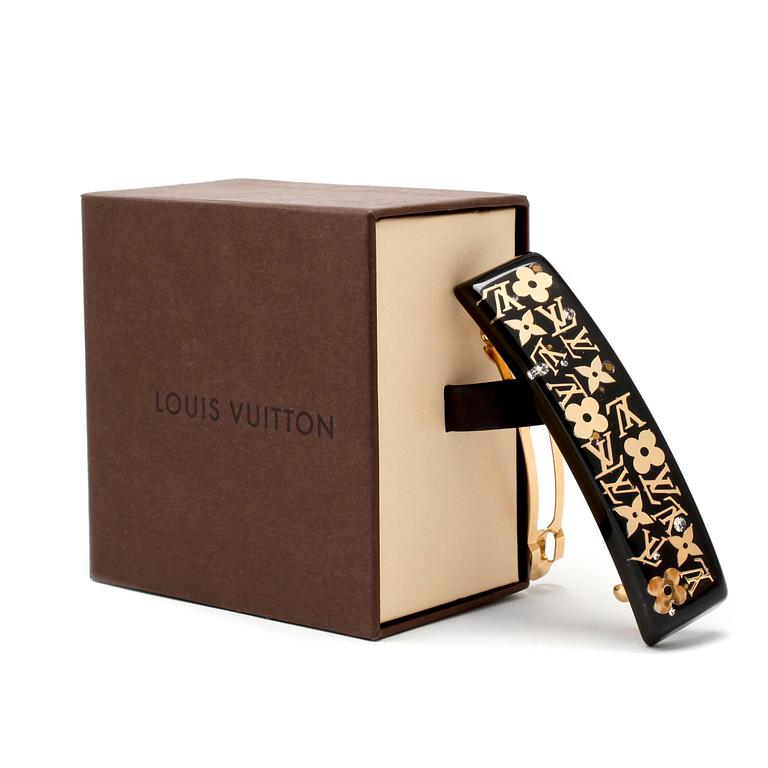 LOUIS VUITTON, a black acrylic and gold hair clip.