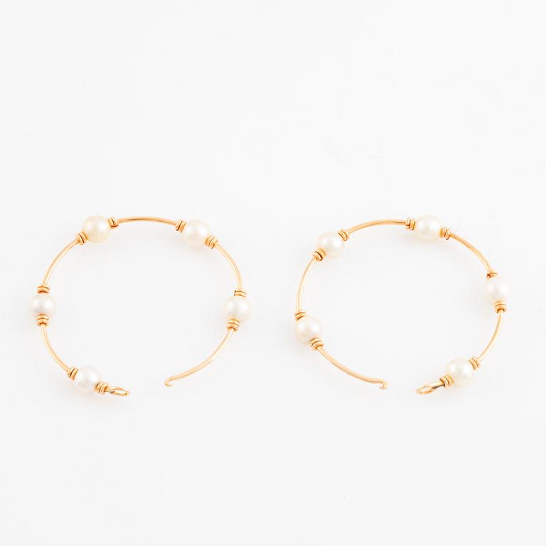 Gold and pearl hoop earrings.
