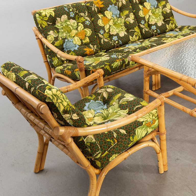 A set of ratten furniture, late 20th century; sofa, armchairs and a lounge table.
