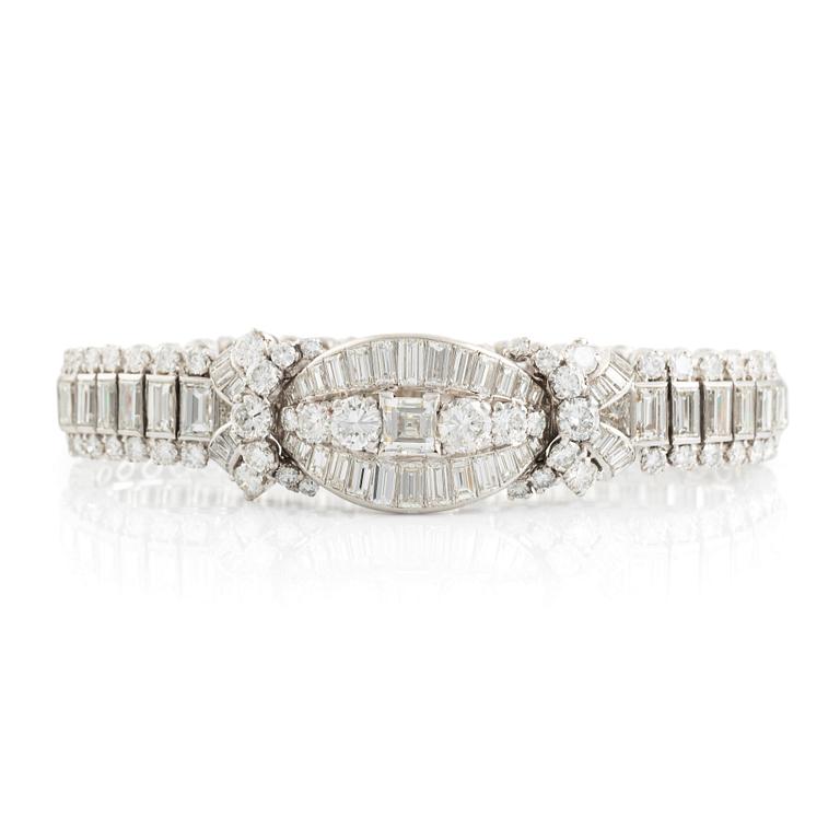 A platinum bracelet set with step-cut and brilliant-cut diamonds.