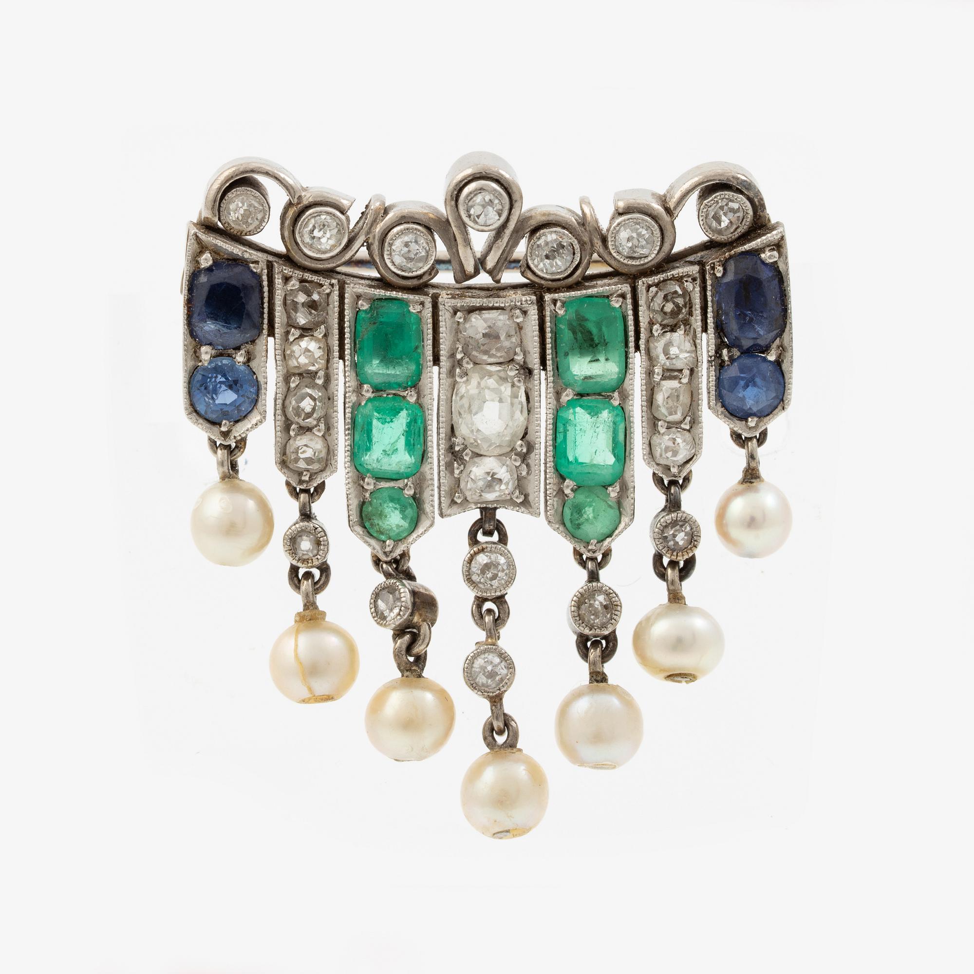 Brooch in platinum set with old-cut diamonds, sapphires, emeralds, and pearls.