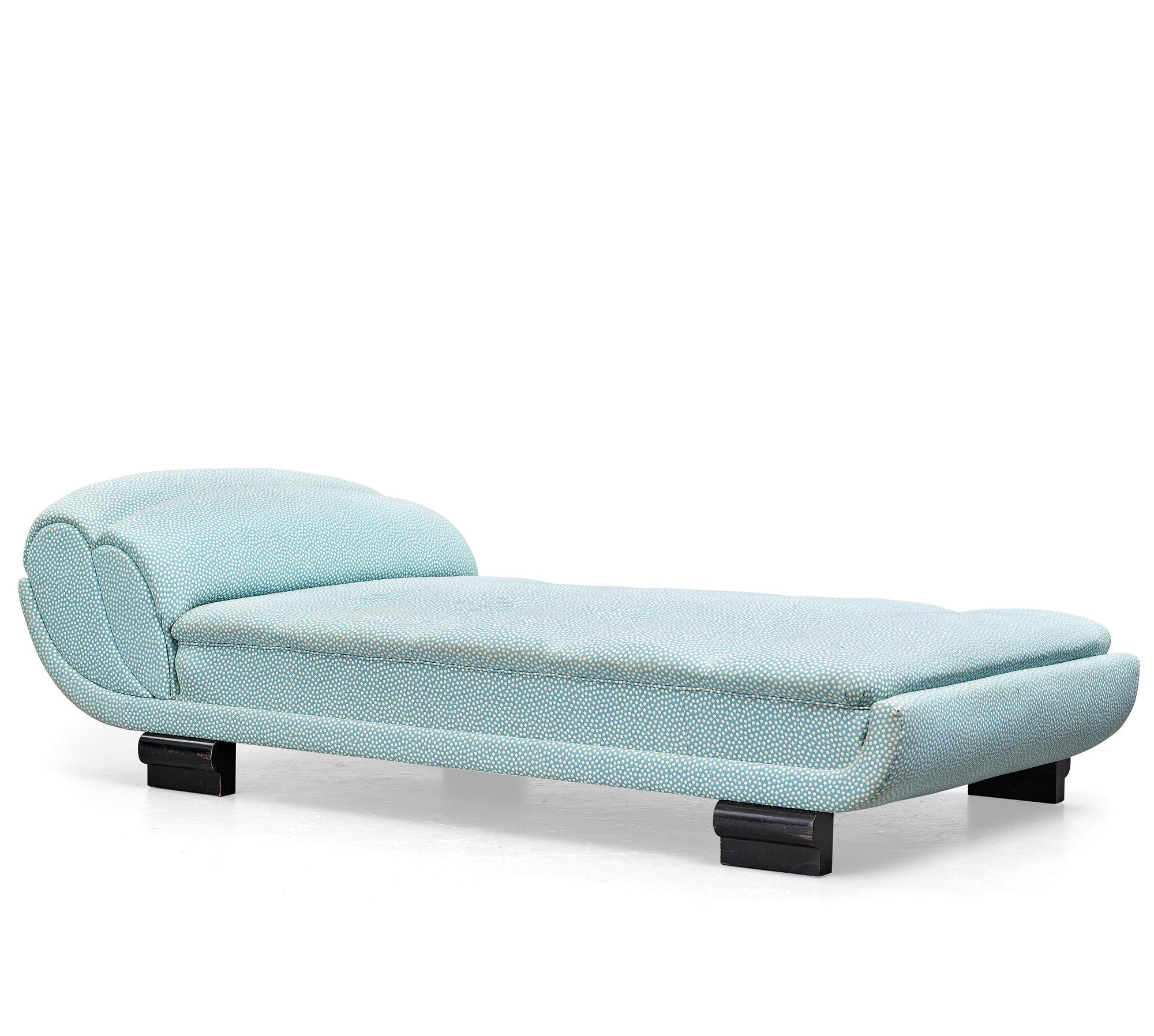 ART DÉCO, an upholstered daybed on shaped black lacquered wooden legs, 1920's-30's.