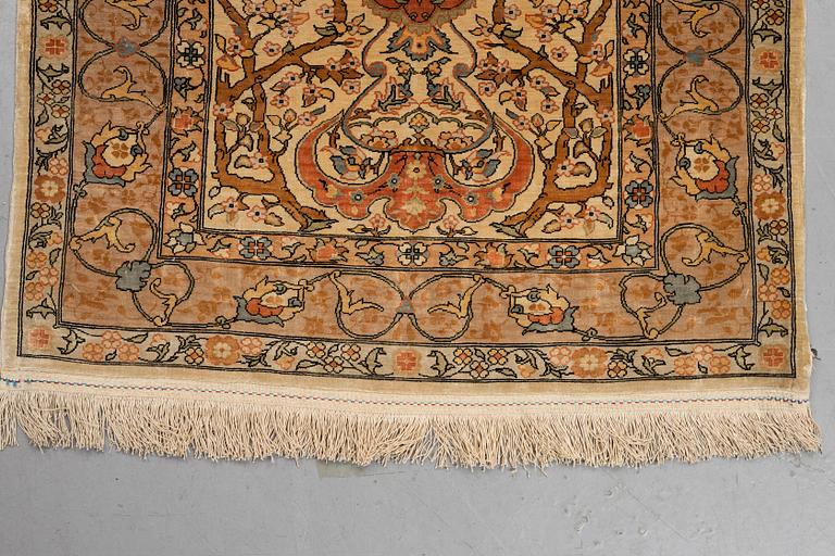 A rug, old silk Hereke, signed, ca 84,5 x 66 cm.