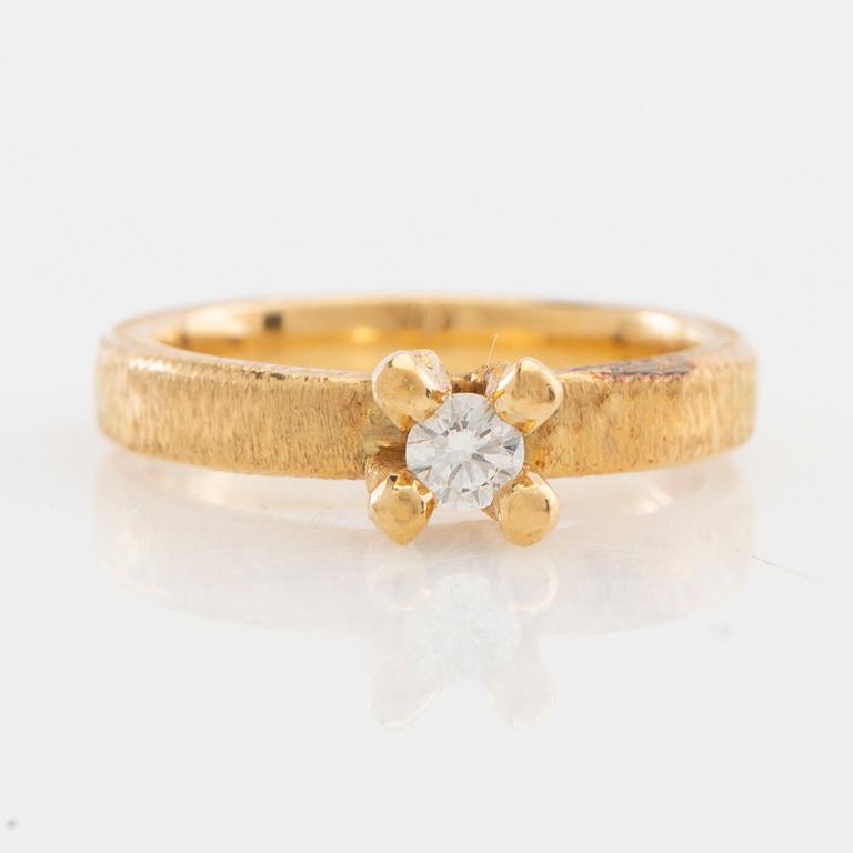 Solitaire ring in 18K gold with a round brilliant-cut diamond.