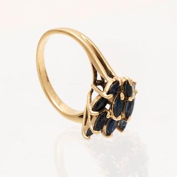 An 18K gold ring with marquise cut sapphires and round brilliant cut diamonds.