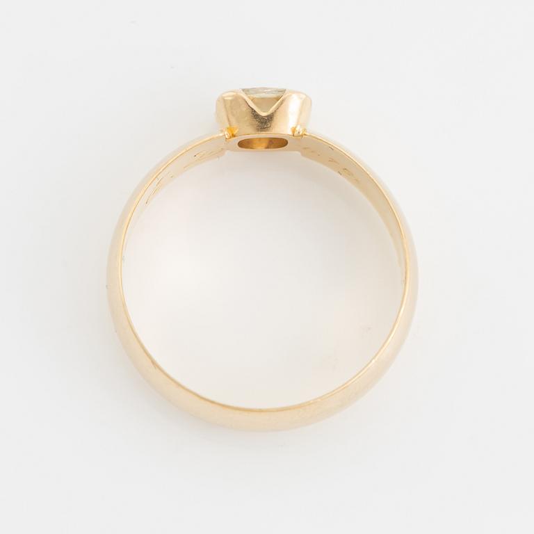 An 18K gold ring set with a radiant-cut diamond.