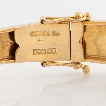 An 18K gold bangle set with synthetic spinel.