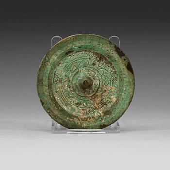A bronze mirror decorated with a highly stylized dragon-pattern, Han dynasty (206 BC - AD 220).
