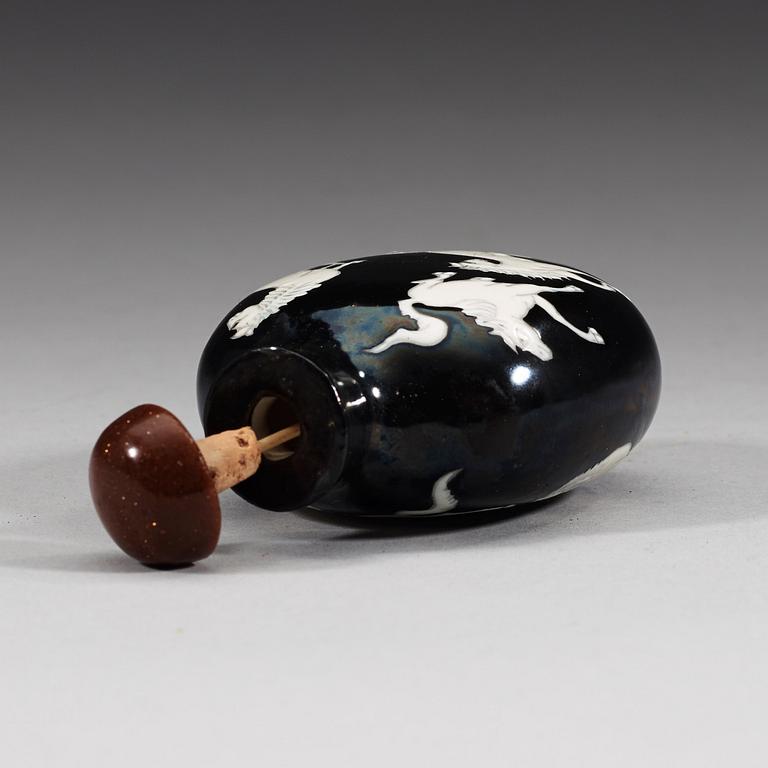 An enamelled porcelain snuff bottle with stopper, Qing dynasty (1644-1912).