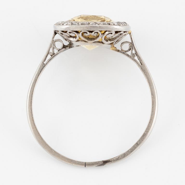 A ring in 18K white gold set with a yellow faceted tourmaline and rose-cut diamonds.