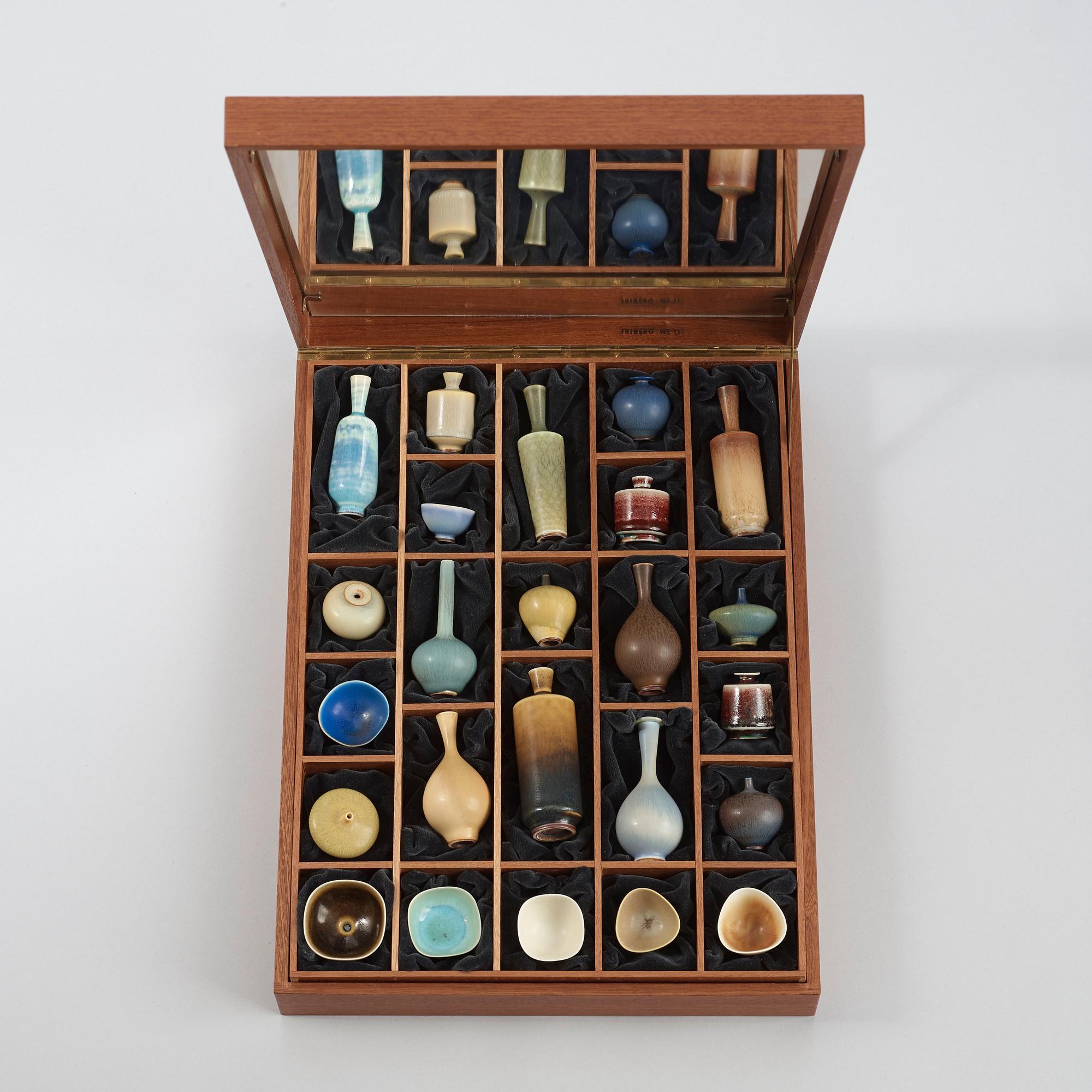 A Berndt Friberg set of 24 miniature stoneware vases and bowls in a teak casket, Gustavsberg Studio.
