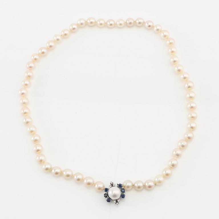 Necklace of cultured pearls with an 18K white gold clasp and round single-cut diamonds and round faceted sapphires.