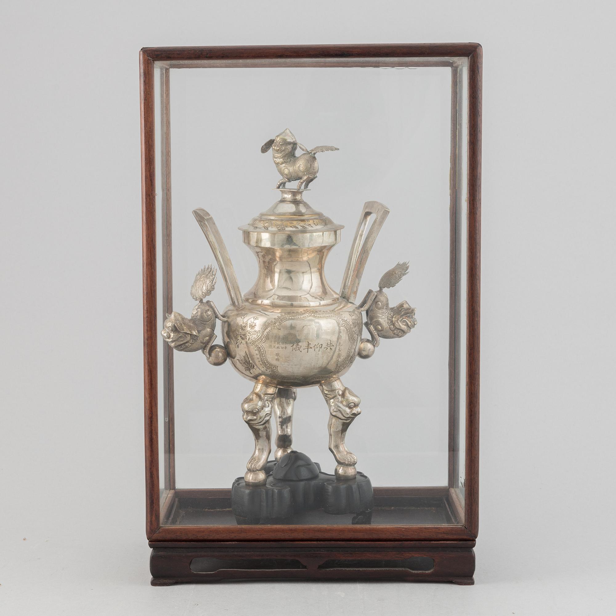 A Chinese metal incense burner in a wooden display case 20th century.