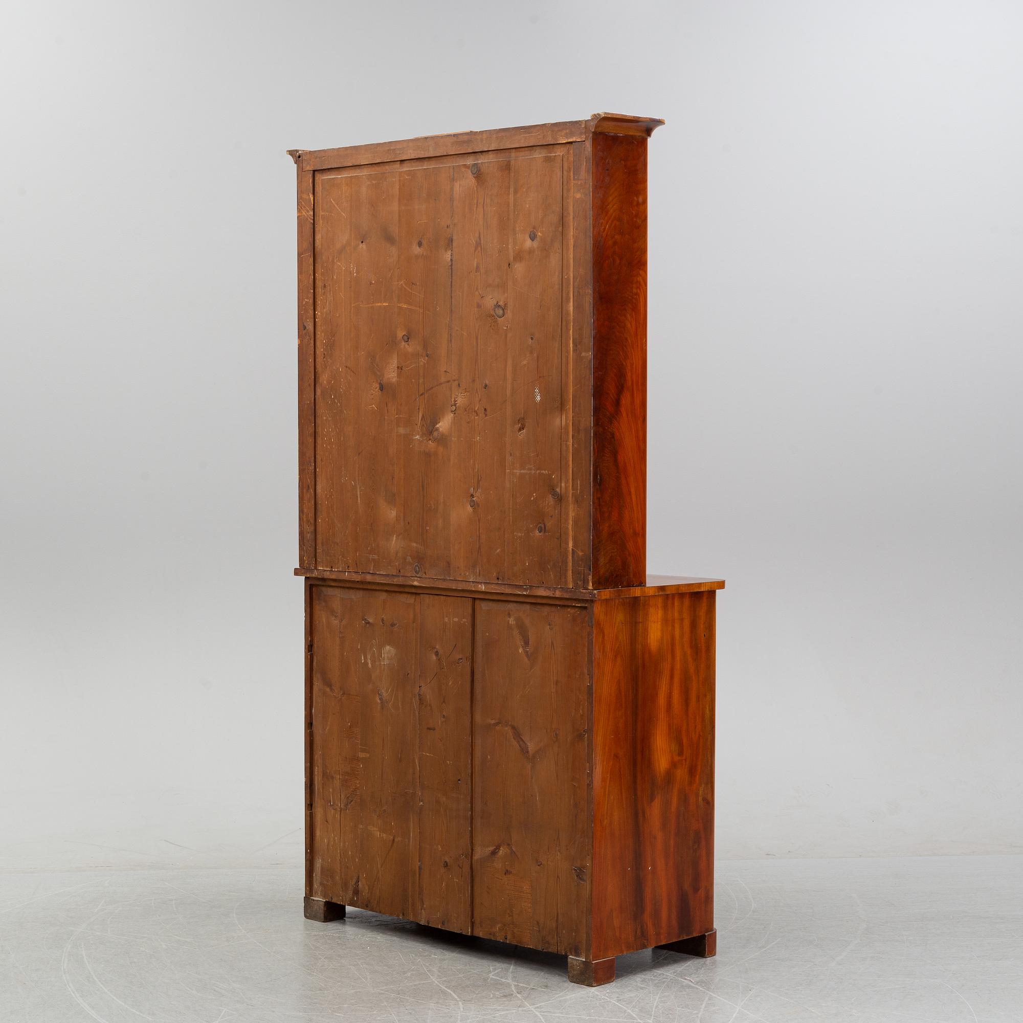 A mahogany veneered Empire cupboard, first half of the 19th century.