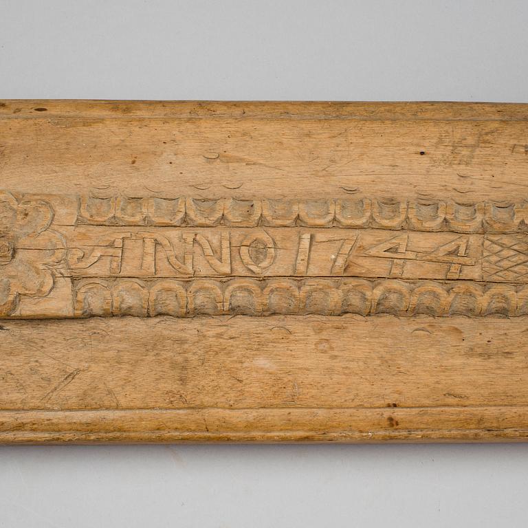 A Swedish folk art mangle board with carved decorationd, owners' initials and the date 1744.
