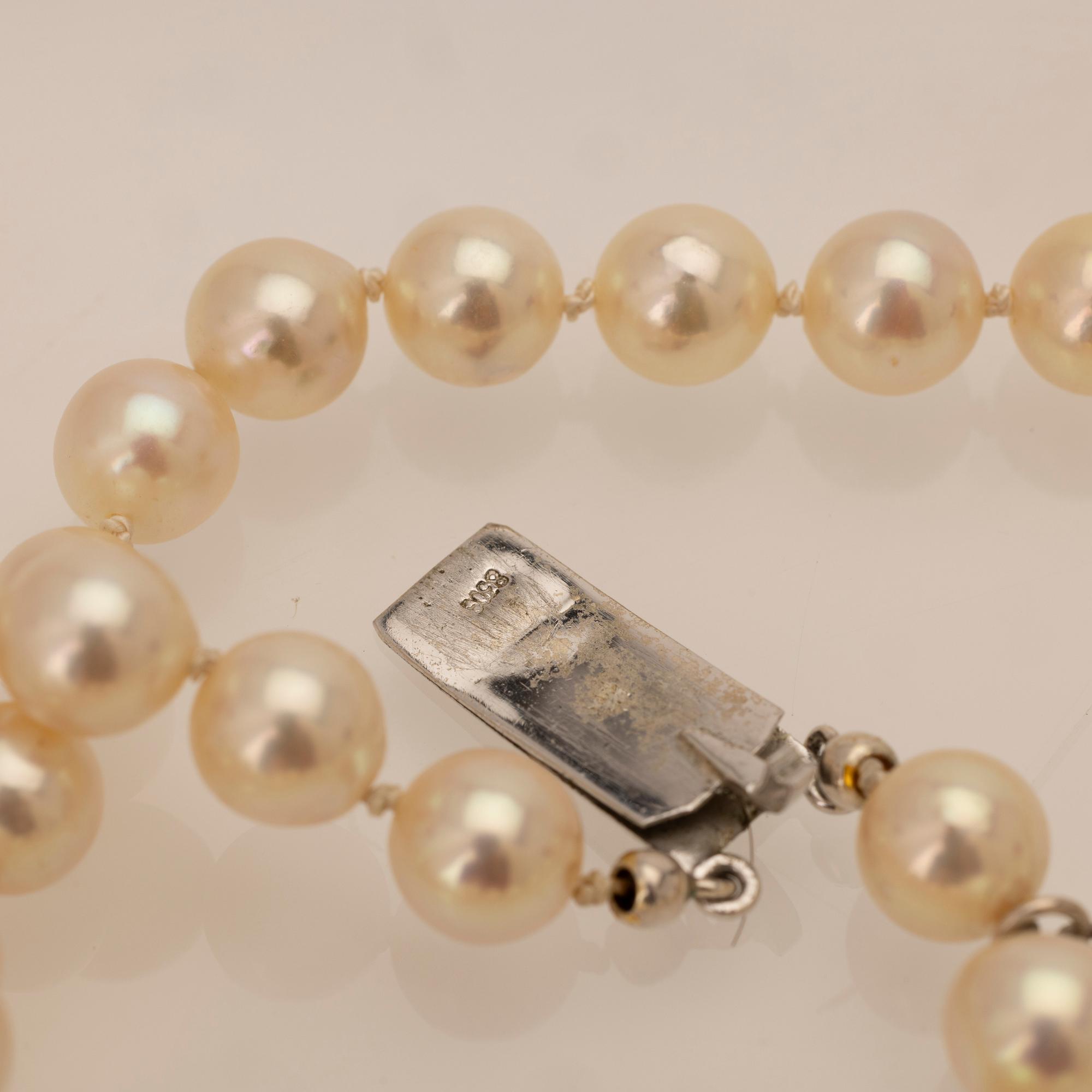 Two-row cultured pearl necklace with a silver and glass clasp.