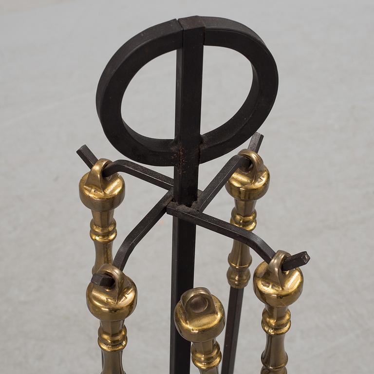 A set of 5 iron and brass fire utensils with stand, 20th Century.