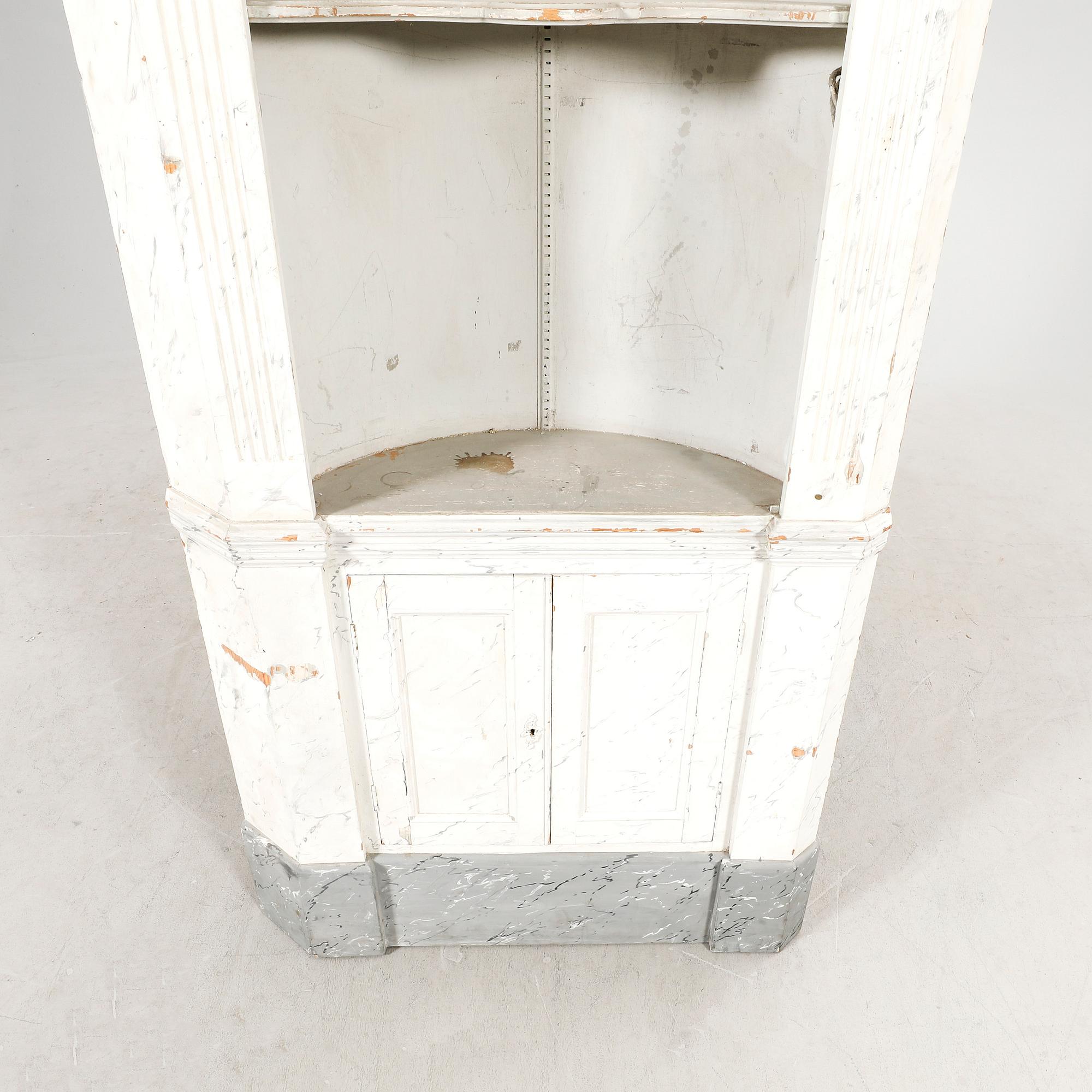 A painted Louis XVI style wallmounted corner cabinet.
