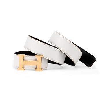 532. HERMÈS, a reversible belt, white and black with gold colored H belt buckle.