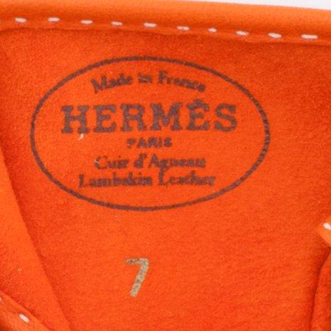 HERMÈS, a pair of orange lambskin leather gloves.