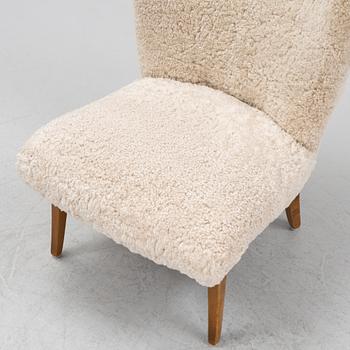 A mid 20th Century easy chair with sheepskin upholstery.