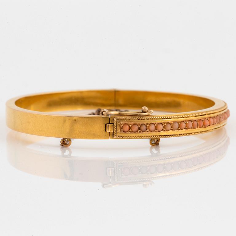 An 18K gold bracelet set with coral.