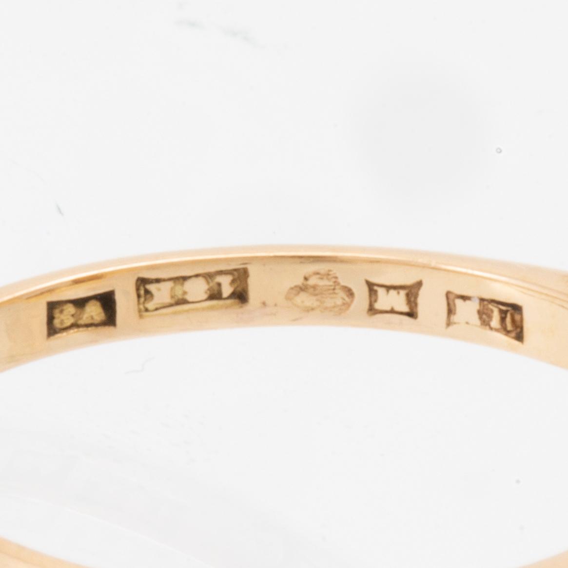 An 18K gold ring set with a step-cut synthetic white spinel.